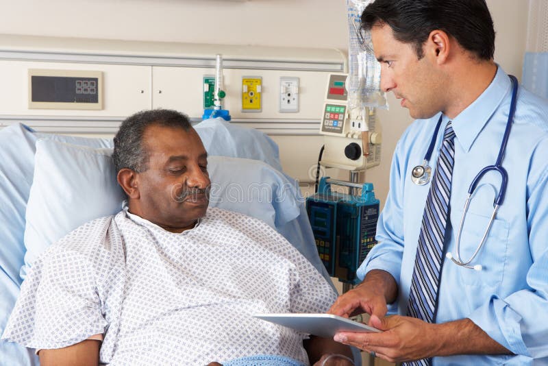 Male Doctor Using Digital Tablet In Consultation With Senior Patient. Male Doctor Using Digital Tablet In Consultation With Senior Patient