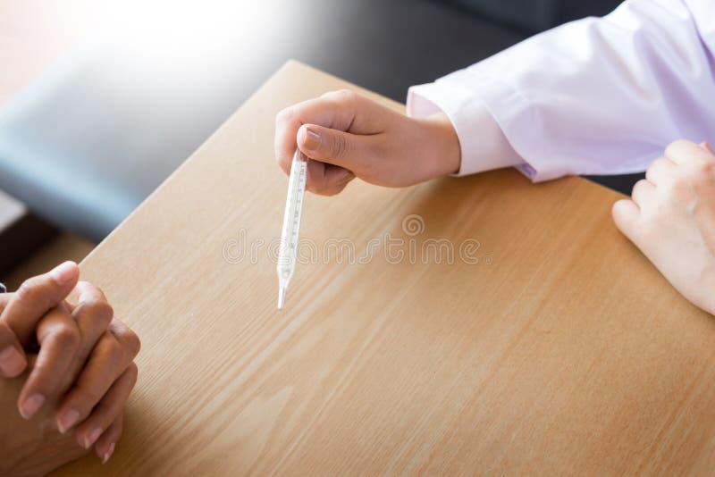 Arts met een thermometer in zijn hand die geduldige ` s in hospit nemen royalty-vrije stock foto's Arts met een thermometer in zijn hand die geduldige ` s in hospit nemen royalty-vrije stock foto's