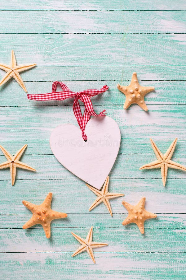 Artículos marinos (estrellas de mar) y corazón decorativo en la turquesa wo imagen de archivo Artículos marinos (estrellas de mar) y corazón decorativo en la turquesa wo imagen de archivo
