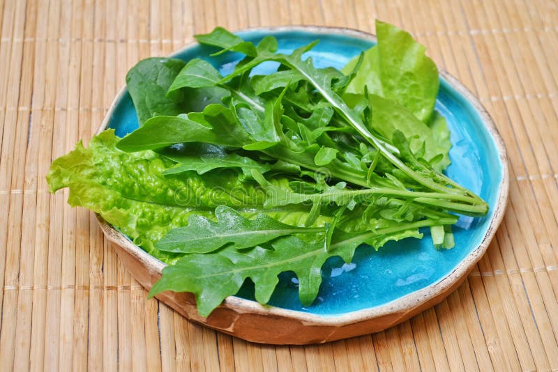 Arugula van de de saladespinazie van de zomer groene groenten in blauwe plaat op houten oppervlakte royalty-vrije stock foto Arugula van de de saladespinazie van de zomer groene groenten in blauwe plaat op houten oppervlakte royalty-vrije stock foto