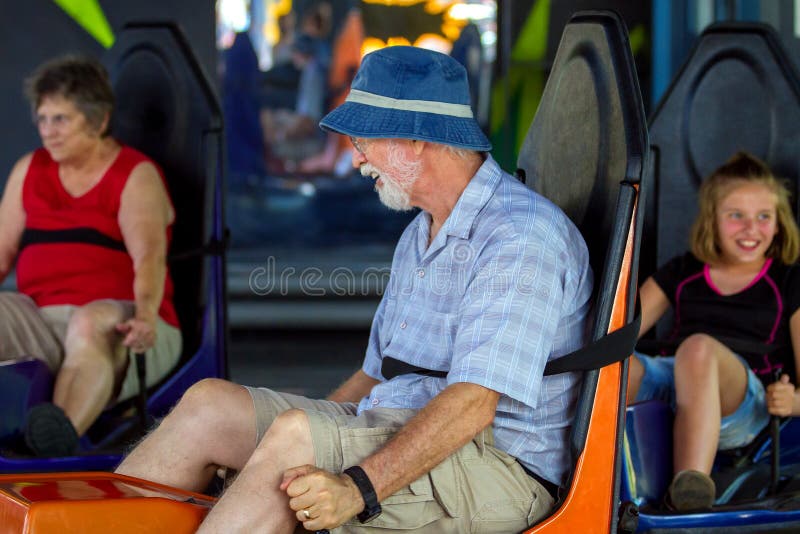 As avós e Grandaughter montam carros abundantes em um divertimento P fotografia de stock As avós e Grandaughter montam carros abundantes em um divertimento P fotografia de stock