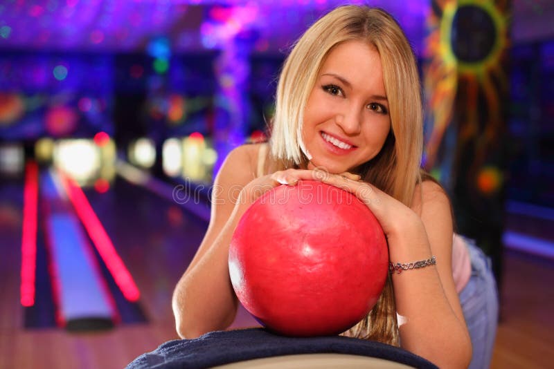 As bases felizes da menina na esfera no bowling batem