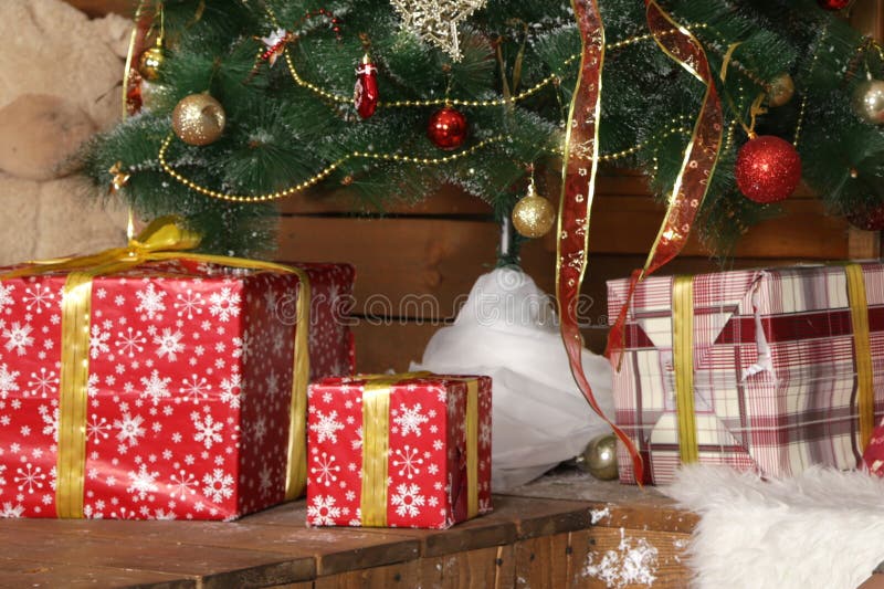 As caixas de presente de época natalícia estão sob a árvore de Natal no interior de ano novo fotos de stock As caixas de presente de época natalícia estão sob a árvore de Natal no interior de ano novo fotos de stock