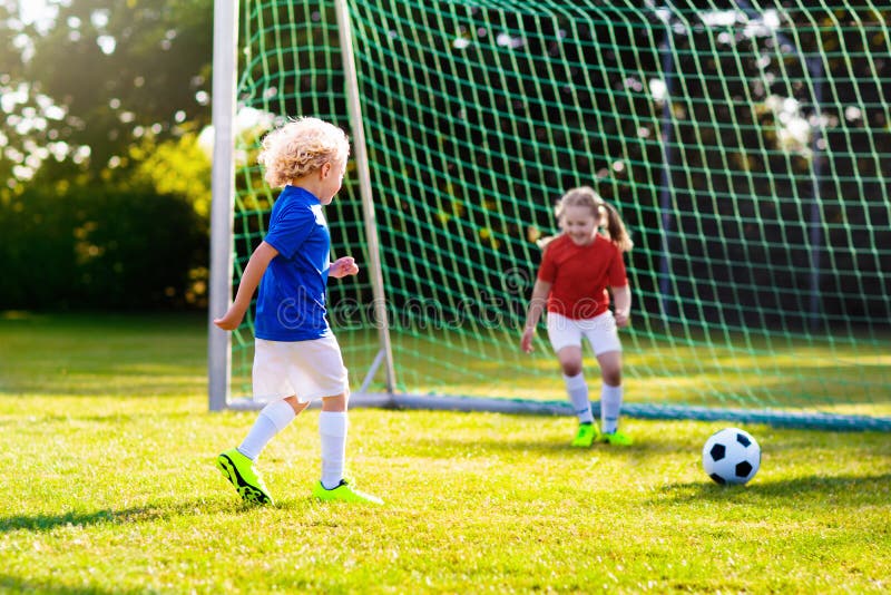 Crianças Jogam Jogo De Futebol. Crianças Em Duas Equipes Chutando