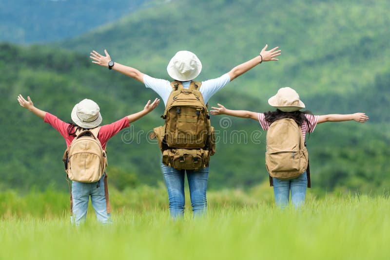 As crianças asiáticas da família do grupo aumentam os braços e a posição considera o ar livre, a aventura e o turismo para o dest