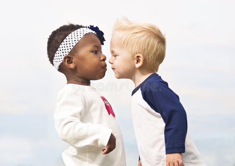 As crianças diversas beijam primeiramente
