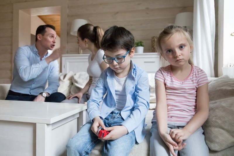 As crianças tristes escutam pais têm o headshot irritado da luta em casa imagem de stock As crianças tristes escutam pais têm o headshot irritado da luta em casa imagem de stock