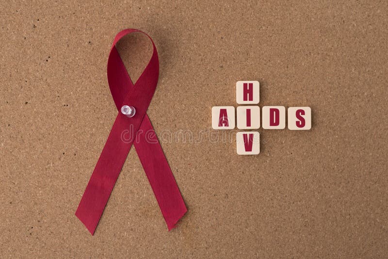 As fitas vermelhas ajudam à fita com palavra de AIDS/HIV no quadro de mensagens