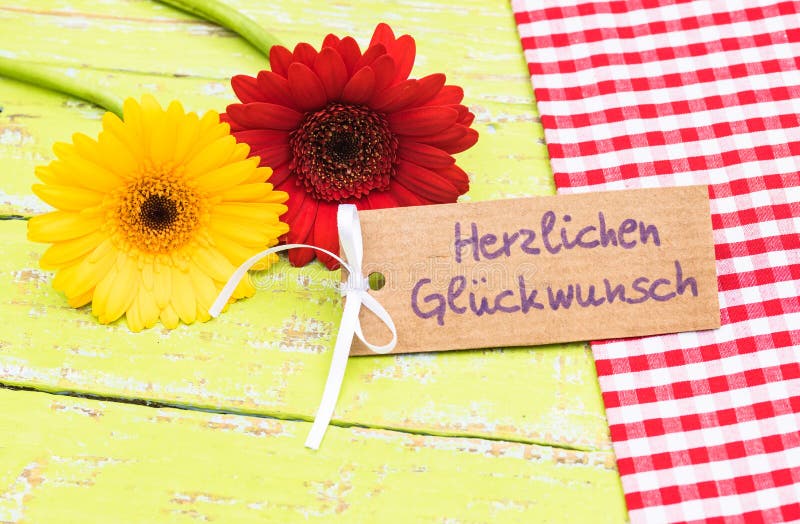 As flores e o cartão coloridos com texto alemão, Herzlichen Glueckwunsch, significam felicitações fotos de stock royalty free As flores e o cartão coloridos com texto alemão, Herzlichen Glueckwunsch, significam felicitações fotos de stock royalty free