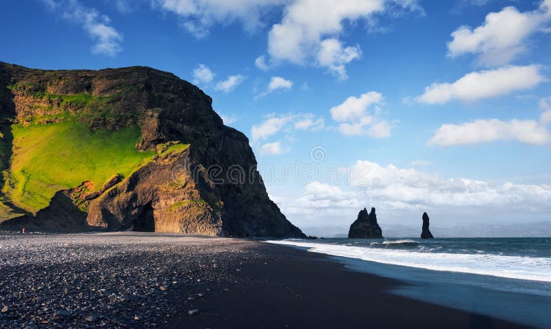 As formações de rocha famosas de Reynisdrangar em Reynisfjara preto encalham Costa do Oceano Atlântico perto de Vik, Islândia do