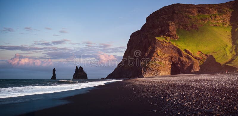 As formações de rocha famosas de Reynisdrangar em Reynisfjara preto encalham Costa do Oceano Atlântico perto de Vik, Islândia do