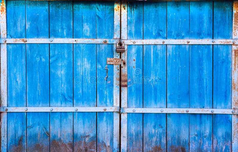 As grandes portas de madeira velhas pintadas em azul e em fechado no cadeado A porta azul no fechamento Close up de madeira das p imagens de stock As grandes portas de madeira velhas pintadas em azul e em fechado no cadeado A porta azul no fechamento Close up de madeira das p imagens de stock