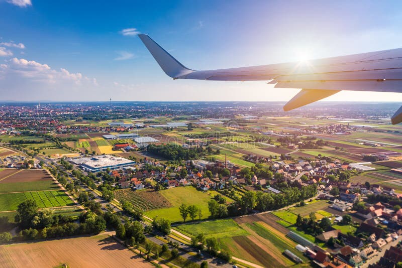 As janelas do avião veem acima da terra no marco para baixo Vista de uma janela do avião sobre uma elevação do voo da asa acima d imagem de stock As janelas do avião veem acima da terra no marco para baixo Vista de uma janela do avião sobre uma elevação do voo da asa acima d imagem de stock