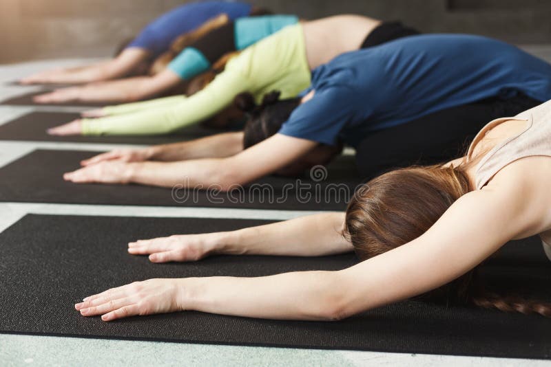 Young women and men in yoga class, meditation exercises. Pose for relaxation. Healthy lifestyle in fitness club, crop, copy space. Young women and men in yoga class, meditation exercises. Pose for relaxation. Healthy lifestyle in fitness club, crop, copy space