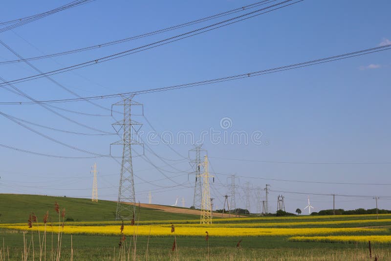 As linhas elétricas de alta tensão cruzam a estação elétrica do mestnost montanhoso no verão sob o céu aberto Indústria prendida fotos de stock royalty free As linhas elétricas de alta tensão cruzam a estação elétrica do mestnost montanhoso no verão sob o céu aberto Indústria prendida fotos de stock royalty free