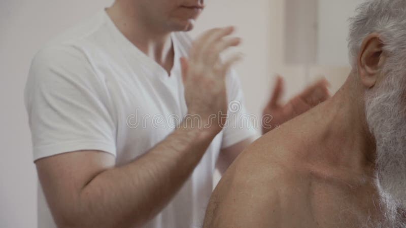 As massagens profissionais do massagista suportam do ancião