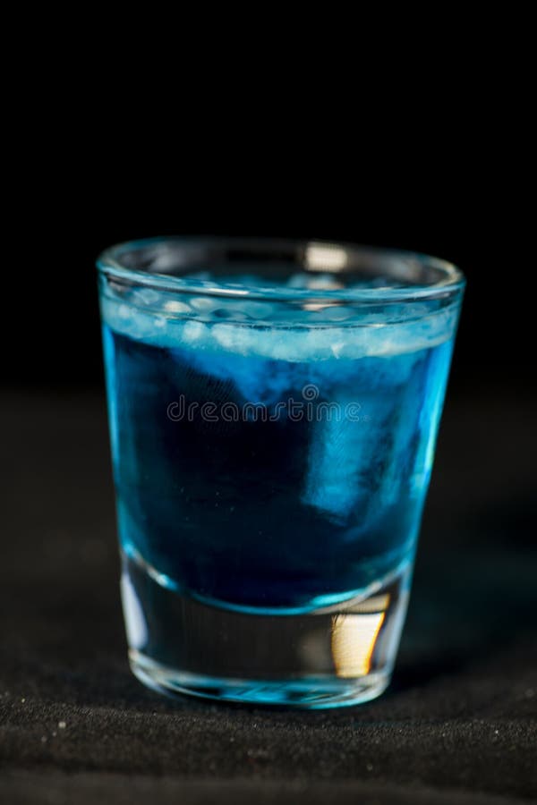 As medusa dispararam no cocktail com Curaçau, o sambuca, vodca e leite azuis imagens de stock As medusa dispararam no cocktail com Curaçau, o sambuca, vodca e leite azuis imagens de stock