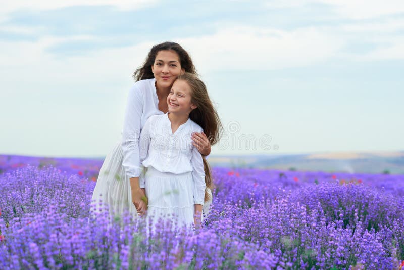 As meninas est?o no campo de flor da alfazema, paisagem bonita do ver?o imagens de stock royalty free As meninas est?o no campo de flor da alfazema, paisagem bonita do ver?o imagens de stock royalty free