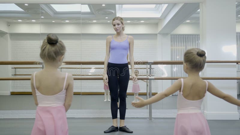 As meninas são prática com o professor na escola do bailado dentro