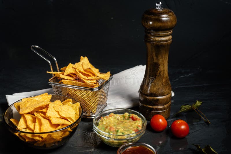 As microplaquetas de tortilha dos Nachos com queijo derretido serviram com guacamole imagens de stock royalty free As microplaquetas de tortilha dos Nachos com queijo derretido serviram com guacamole imagens de stock royalty free
