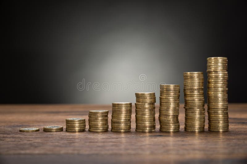 As moedas empilham na tabela fotos de stock As moedas empilham na tabela fotos de stock