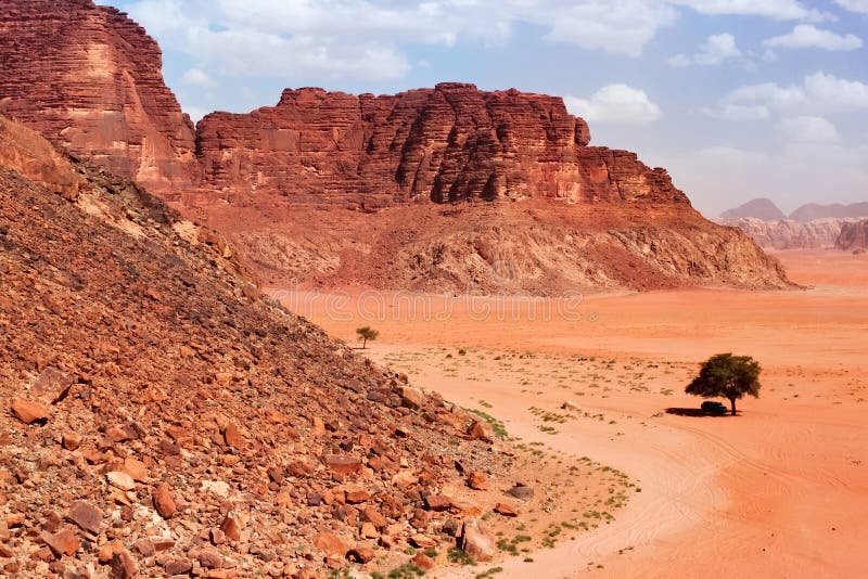 As montanhas vermelhas da garganta de Wadi Rum abandonam em Jordânia imagens de stock As montanhas vermelhas da garganta de Wadi Rum abandonam em Jordânia imagens de stock