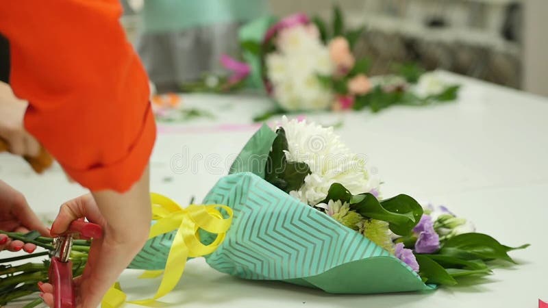 As mulheres aprendem fazer o design floral sob a orientação de um profissional Um grupo de jovens mulheres na classe de
