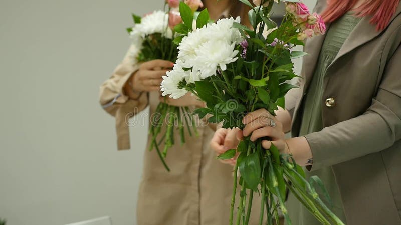 As mulheres aprendem fazer o design floral sob a orientação de um profissional Um grupo de jovens mulheres na classe de