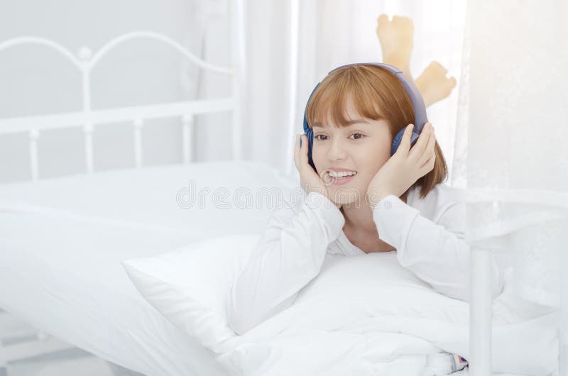 As mulheres asiáticas descansaram na sala Era de sorriso e de escuta a música fotos de stock As mulheres asiáticas descansaram na sala Era de sorriso e de escuta a música fotos de stock