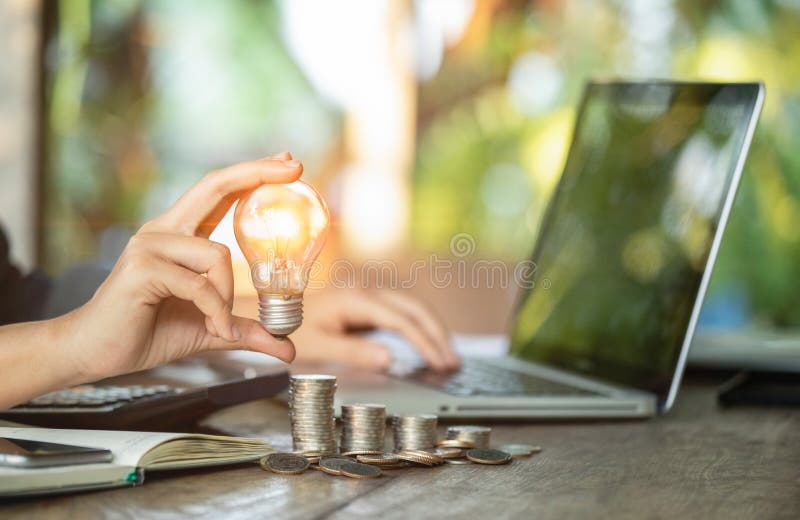 As mulheres de negócio entregam guardar a ampola em moedas da pilha e o trabalho com o computador no local de trabalho Conceito c foto de stock As mulheres de negócio entregam guardar a ampola em moedas da pilha e o trabalho com o computador no local de trabalho Conceito c foto de stock