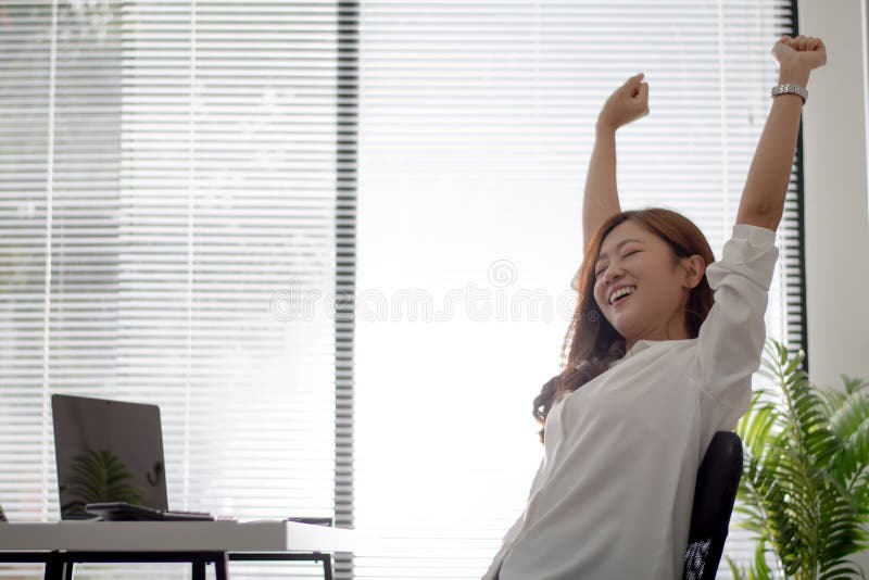 As mulheres trabalhadoras asiáticas estão relaxadas de trabalhar em uma mesa branca no escritório