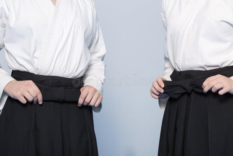 As mãos da menina amarram um hakama imagem de stock royalty free As mãos da menina amarram um hakama imagem de stock royalty free