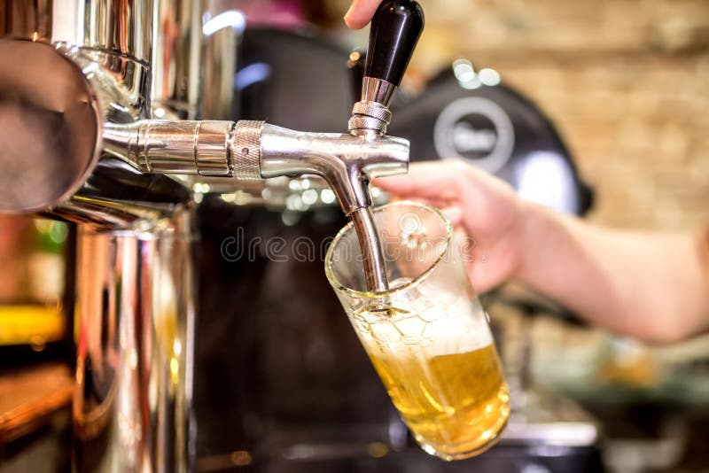 as mãos do empregado de bar na cerveja batem o derramamento de um serviço da cerveja de cerveja pilsen do esboço em um restaurant