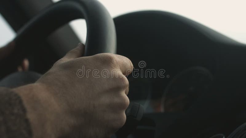 As mãos do homem mantêm o fim do volante