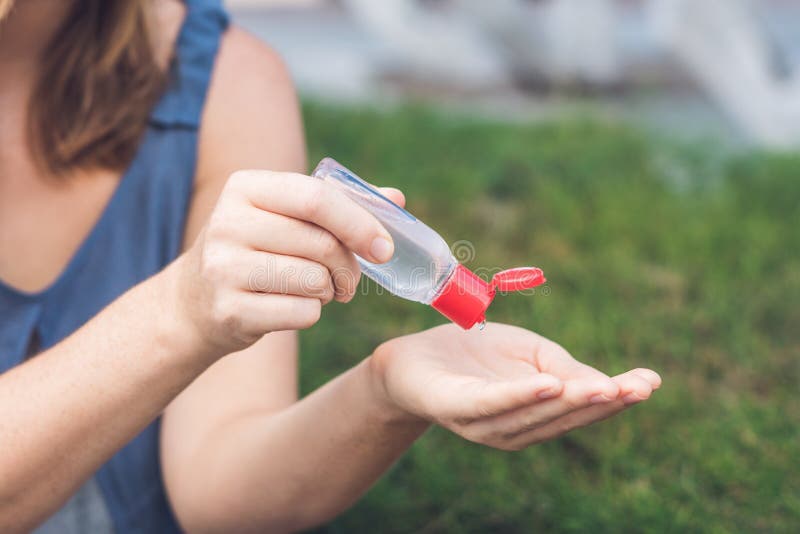 Women`s hands using wash hand sanitizer gel pump dispenser. Women`s hands using wash hand sanitizer gel pump dispenser.