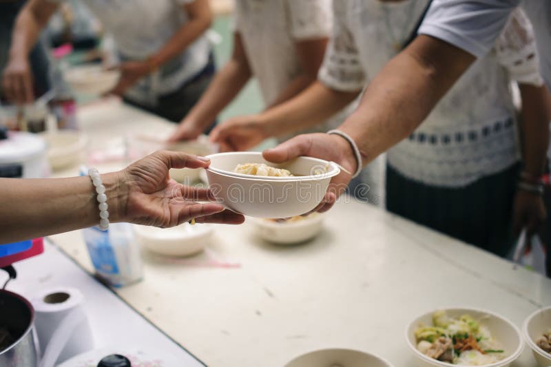 As mãos dos mendigos recebem o alimento doado: O conceito das faltas de alimentos fotografia de stock royalty free