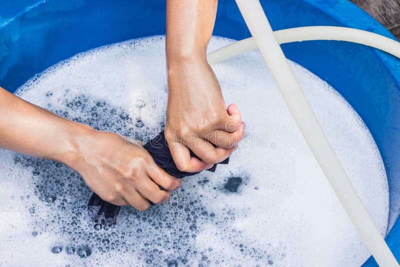 Female hands wash clothing by hand with detergent in basin. selective focus and space for text. Female hands wash clothing by hand with detergent in basin. selective focus and space for text.