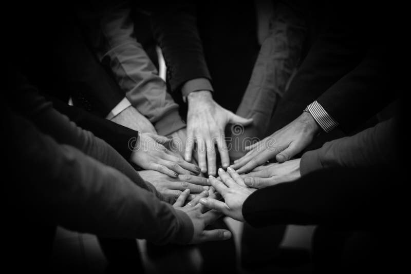 As mãos juntadas de um grupo de pessoas foto de stock As mãos juntadas de um grupo de pessoas foto de stock