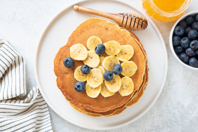 Panquecas de milho com banana, mirtilos e mel fotos de stock