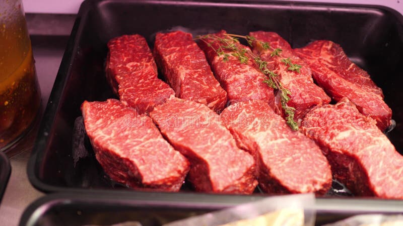 As partes de carne crua fresca da carne do lombinho com alecrins, carne de porco e fatias de bacon est?o encontrando-se em bandej imagens de stock As partes de carne crua fresca da carne do lombinho com alecrins, carne de porco e fatias de bacon est?o encontrando-se em bandej imagens de stock