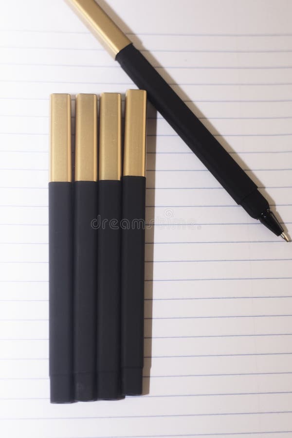 As penas pretas em uma paz alinhada do Livro Branco, aprontam-se para ir para trás à escola ou para ser um material de escritório imagens de stock royalty free As penas pretas em uma paz alinhada do Livro Branco, aprontam-se para ir para trás à escola ou para ser um material de escritório imagens de stock royalty free