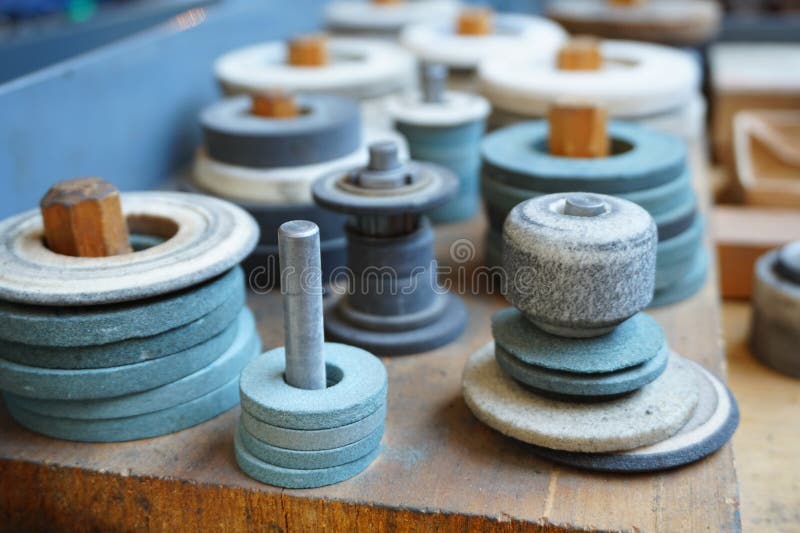 As rodas de moedura abrasivas na cremalheira estão prontas para trabalhar fotos de stock As rodas de moedura abrasivas na cremalheira estão prontas para trabalhar fotos de stock