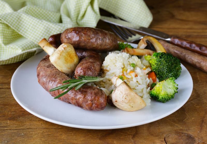 As salsichas caseiros da carne com vegetais decoram fotografia de stock