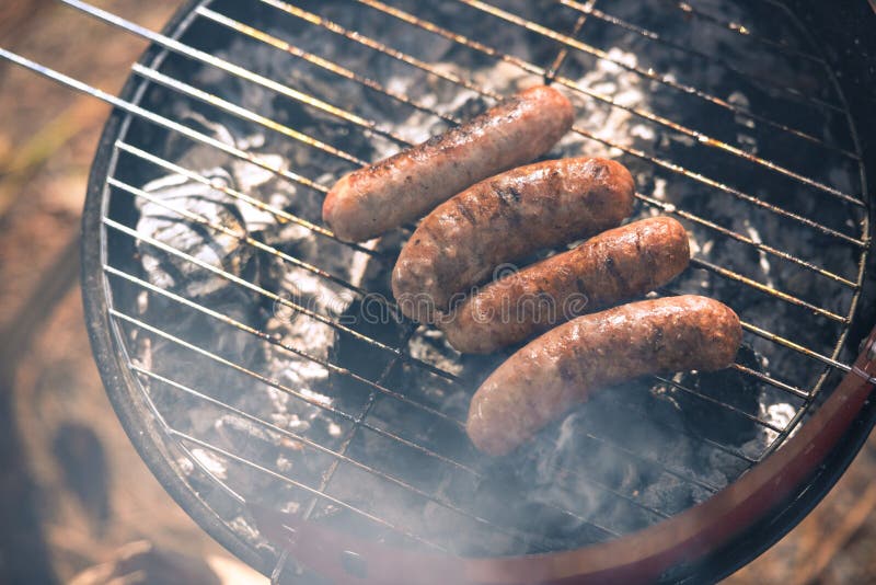 Asado a la parilla de las salchichas en parrilla de la barbacoa imágenes de archivo libres de regalías Asado a la parilla de las salchichas en parrilla de la barbacoa imágenes de archivo libres de regalías
