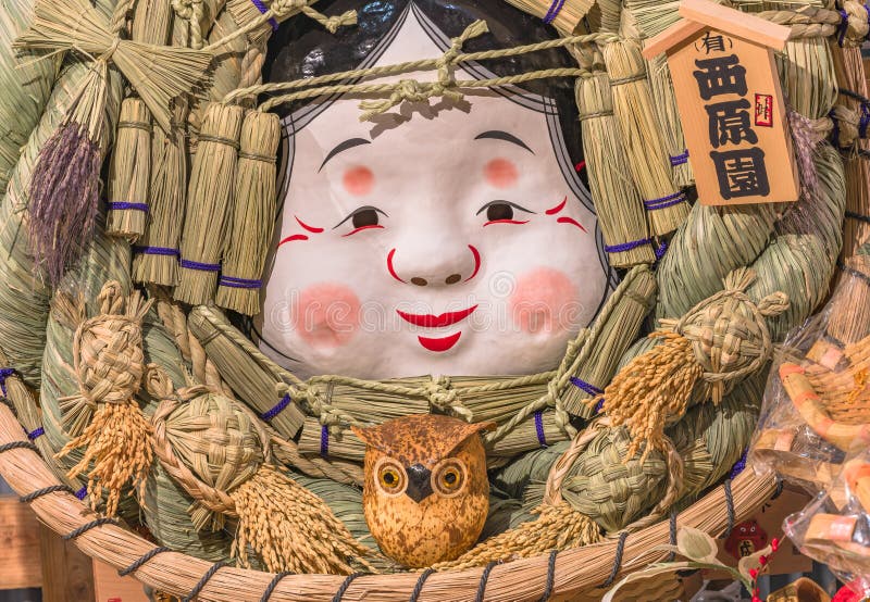 Close-up on an auspicious rake made of straw decorated with the Japanese folklore Okame face.