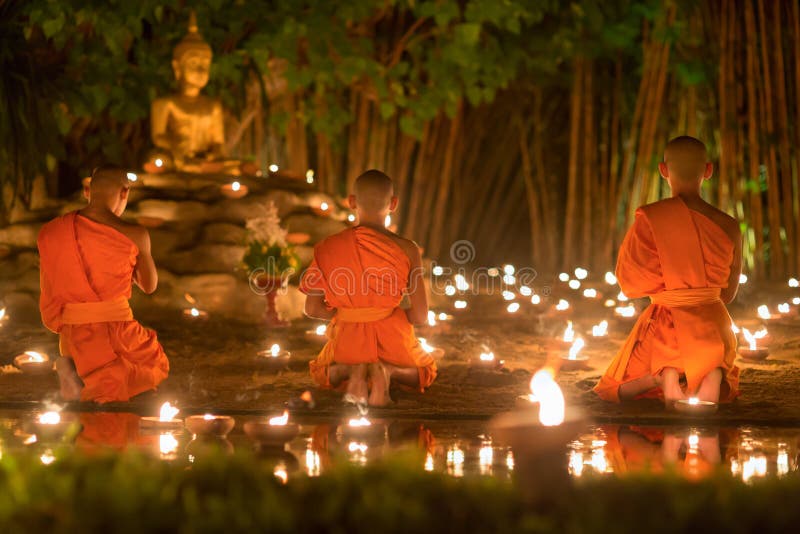 Asalha Puja Day ,Monks pray to buddha statue .