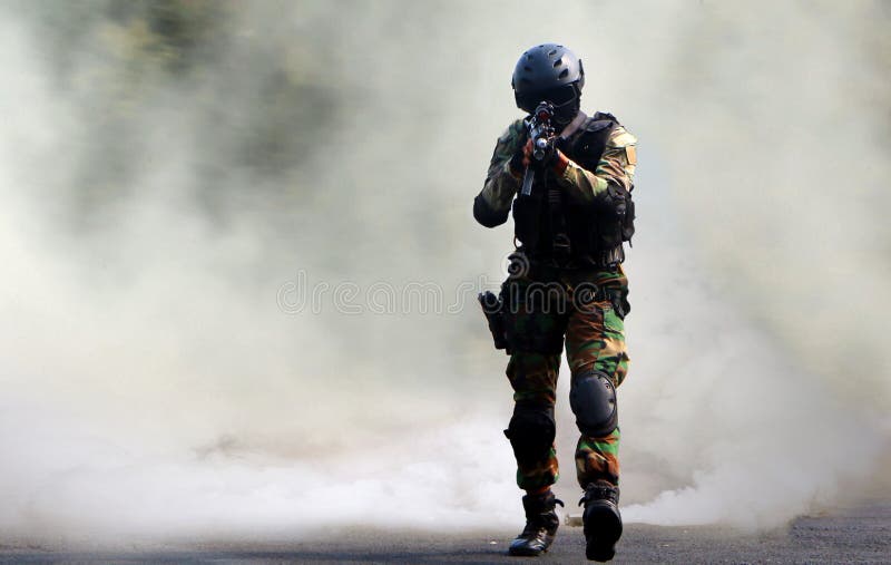 Asalto de la fuerza especial debajo de la pantalla de humo fotografía de archivo libre de regalías Asalto de la fuerza especial debajo de la pantalla de humo fotografía de archivo libre de regalías