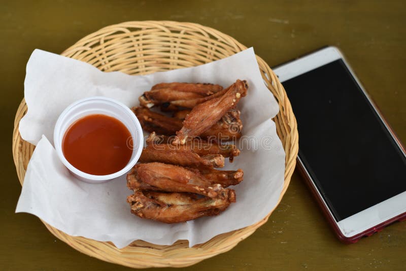Asas de frango frito com mergulhos em uma cesta foto de stock Asas de frango frito com mergulhos em uma cesta foto de stock
