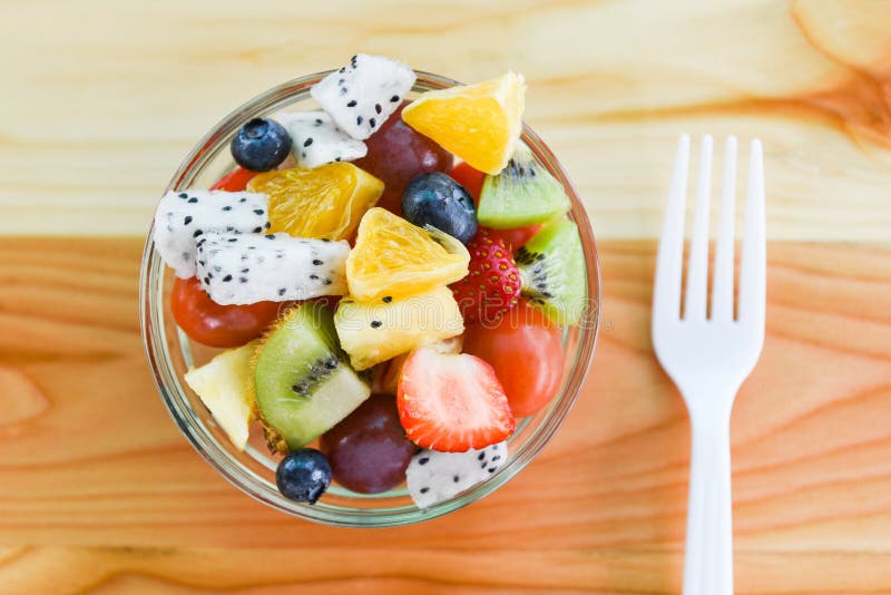 Asciugatura di frutta fresca frutta estiva e verdura fresca alimenti biologici salubri fragole arancio kiwi draghi frutta. Agrossola di frutta frutta fresca frutta estiva e ortaggi freschi alimenti biologici sani fragole arancio kiwi mirtilli draghi frutta uva tropicale pomodoro limone con forchetta sulla tavola da pranzo