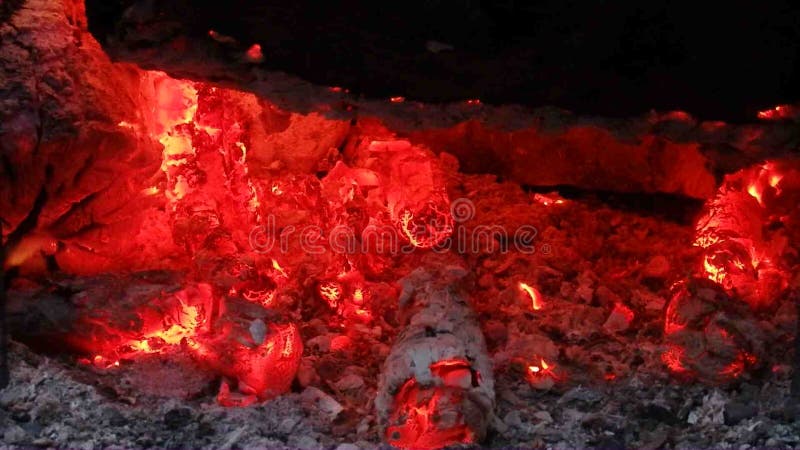 Ascuas candentes debajo de un registro carbonizado